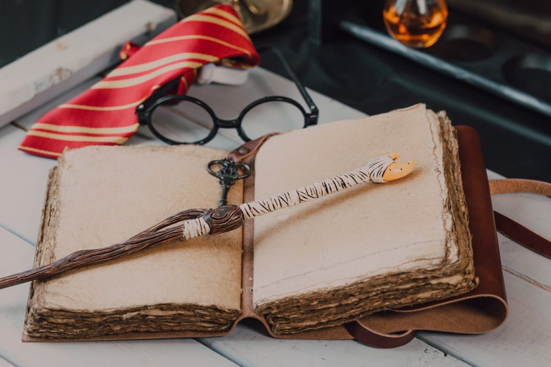 A wand resting on an old spell book